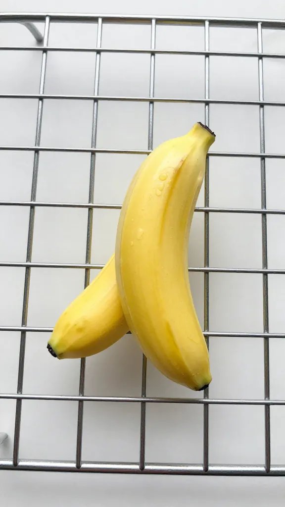single batter-coated banana coin on wire rack