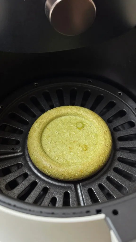 air fryer basket holding one green tea crisp, closeup