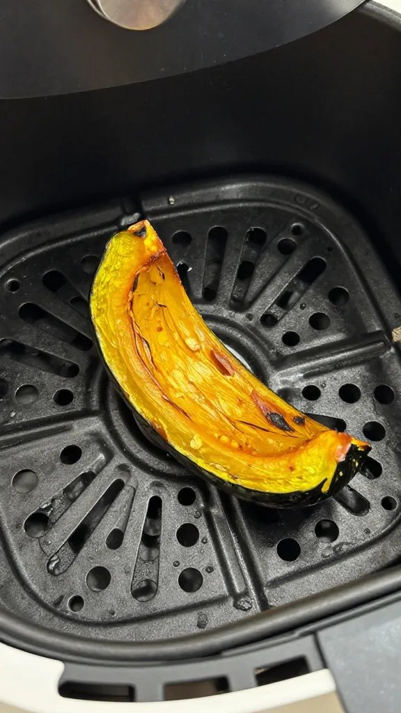 air fryer basket with single roasted squash wedge, closeup