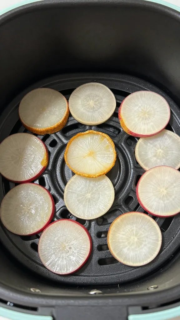air fryer basket with radish chips, golden edges