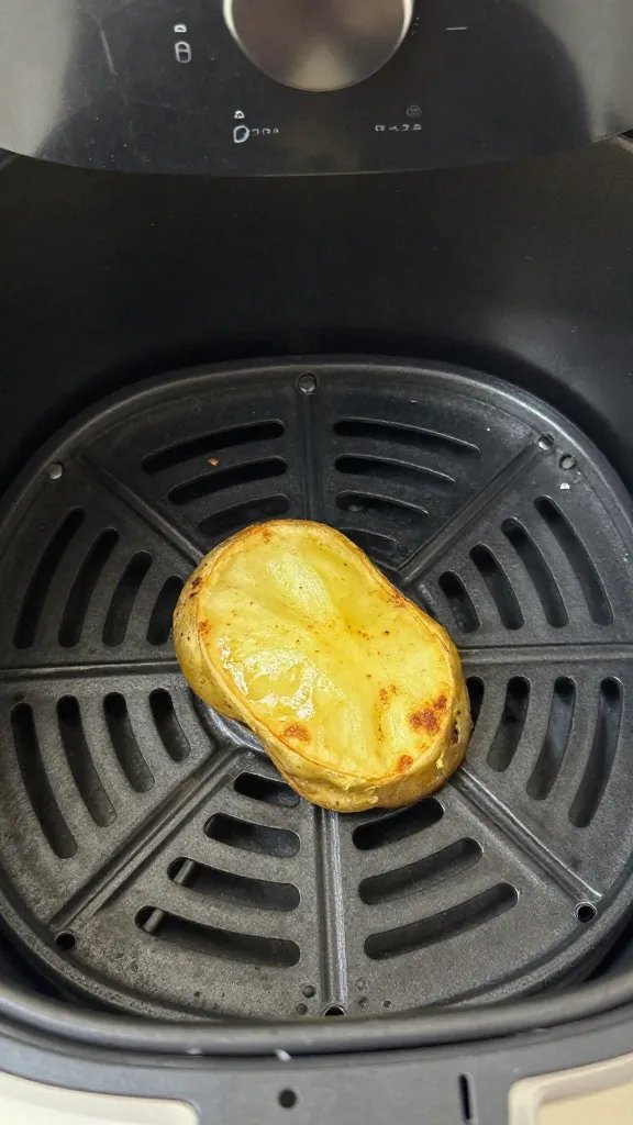 air fryer basket holding one crisp potato skin