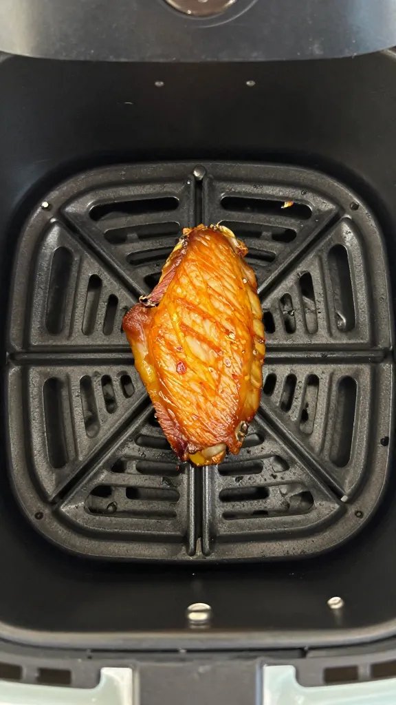 air fryer basket holding one perfectly browned wing
