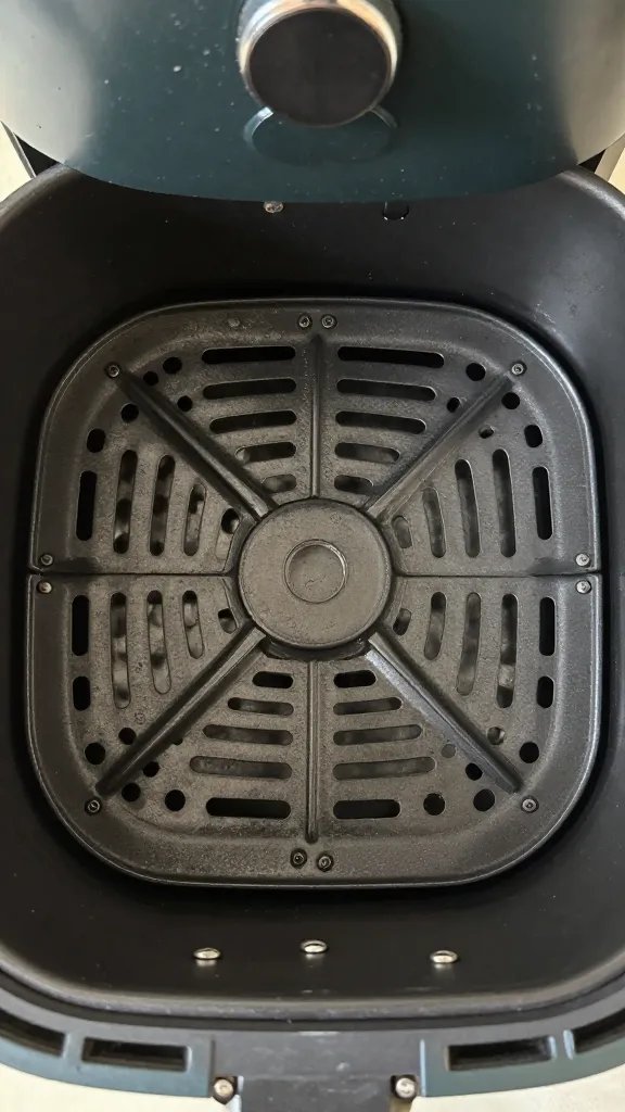 air fryer basket with one wing centered, overhead
