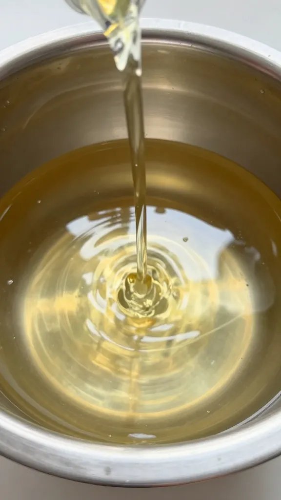 stream of allulose syrup pouring into stainless bowl
