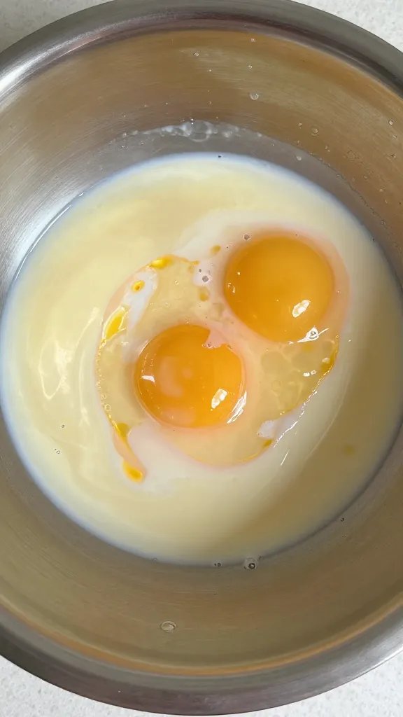 whisked egg and milk mixture in stainless bowl