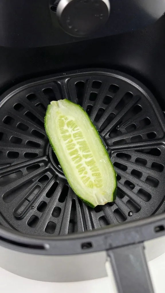 air fryer basket holding one crisp cucumber chip