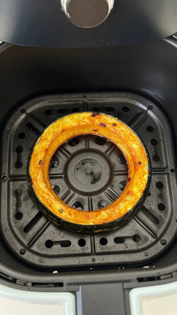 Air fryer basket with one browned spaghetti squash ring