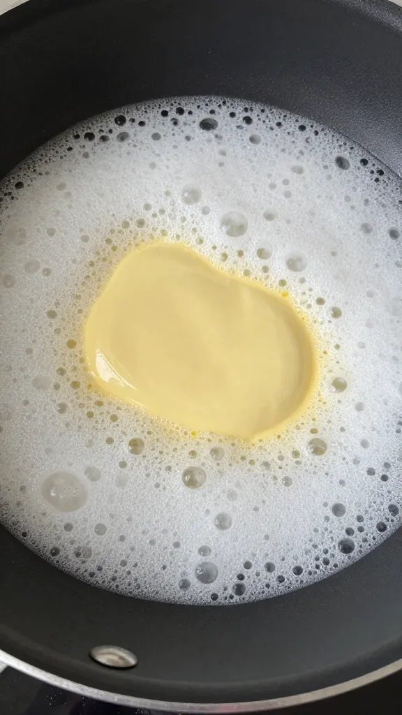Melted butter foaming in small skillet, closeup
